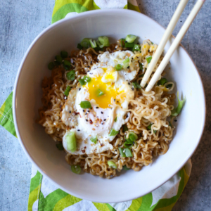 Seasoned ramen noodles in a pan with a fried egg